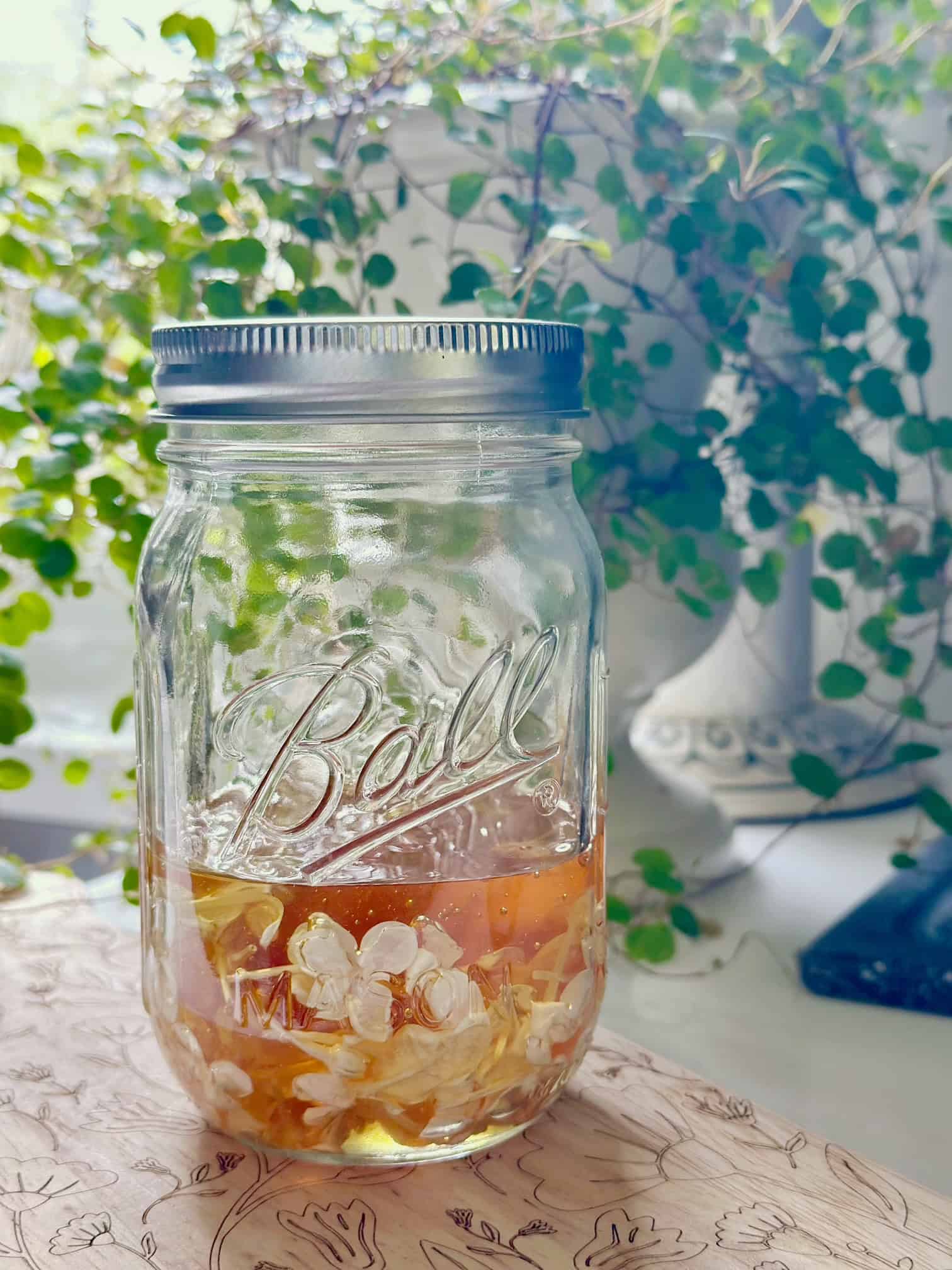 Honey over white flowers in a jar with a cover.