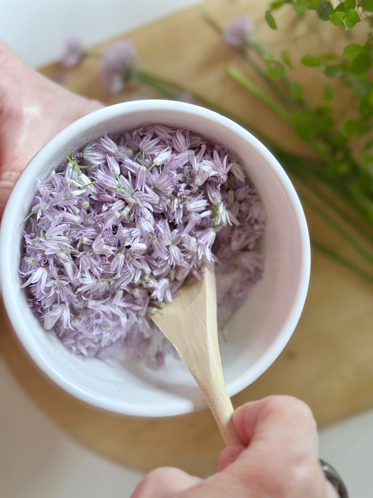 Mixing salt and fresh chive flower florets.