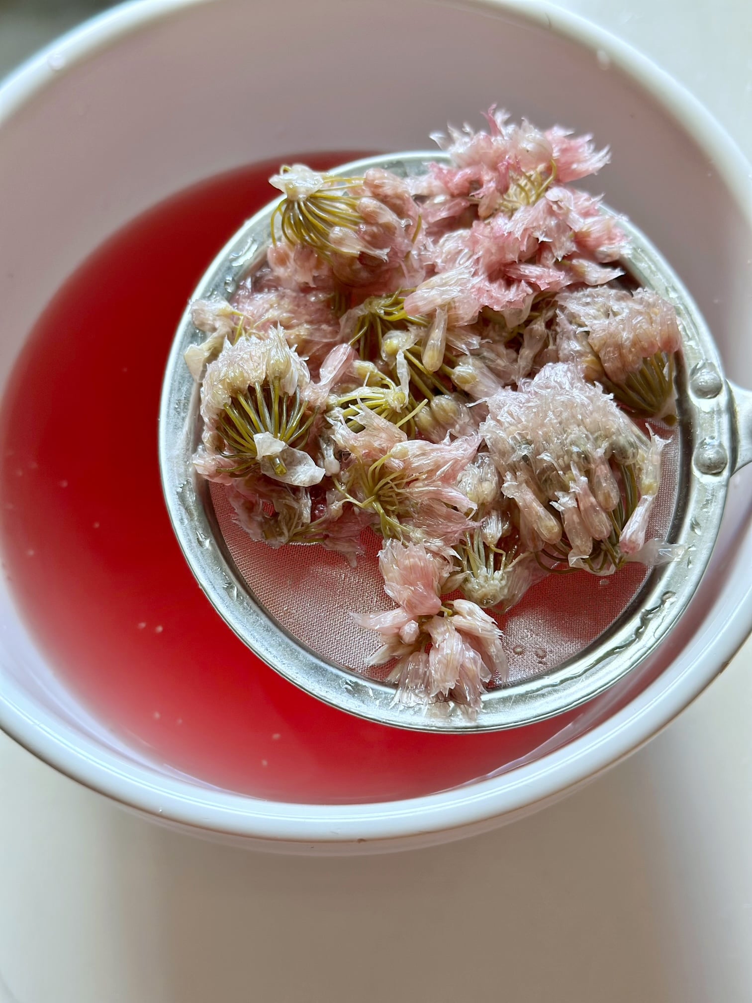 Straining the chive blossoms from the vinegar. 