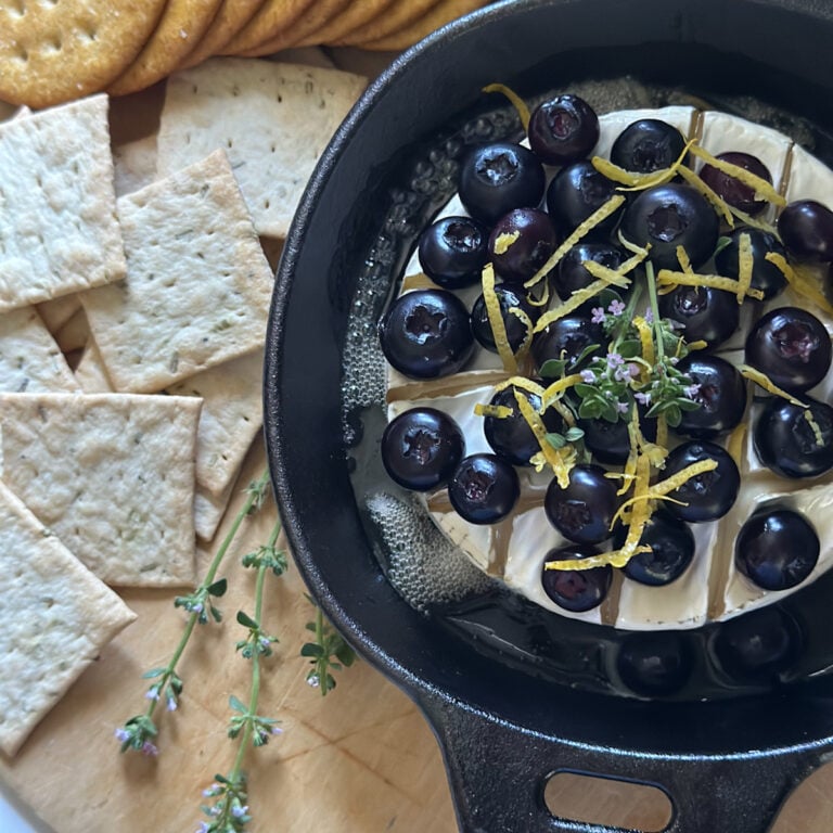 Blueberry baked brie featuring fresh blueberries.