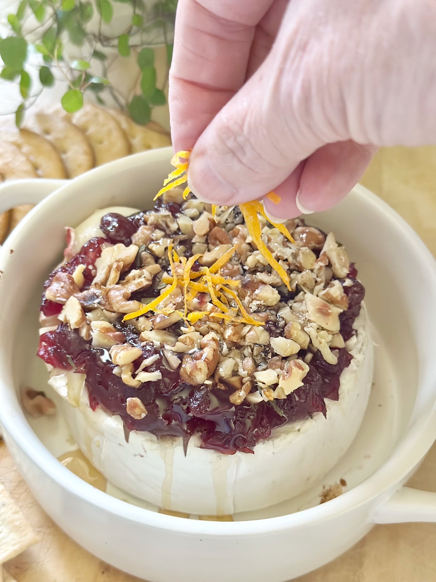 Adding orange zest on baked brie.