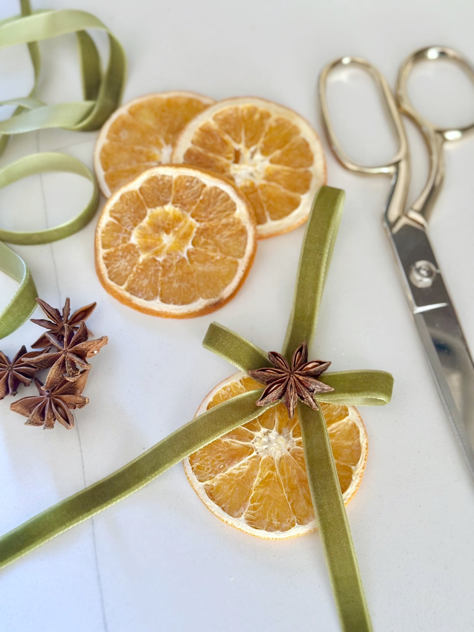 A dried orange slice, star anise and green velvet ribbon to make dried orange ornaments. 