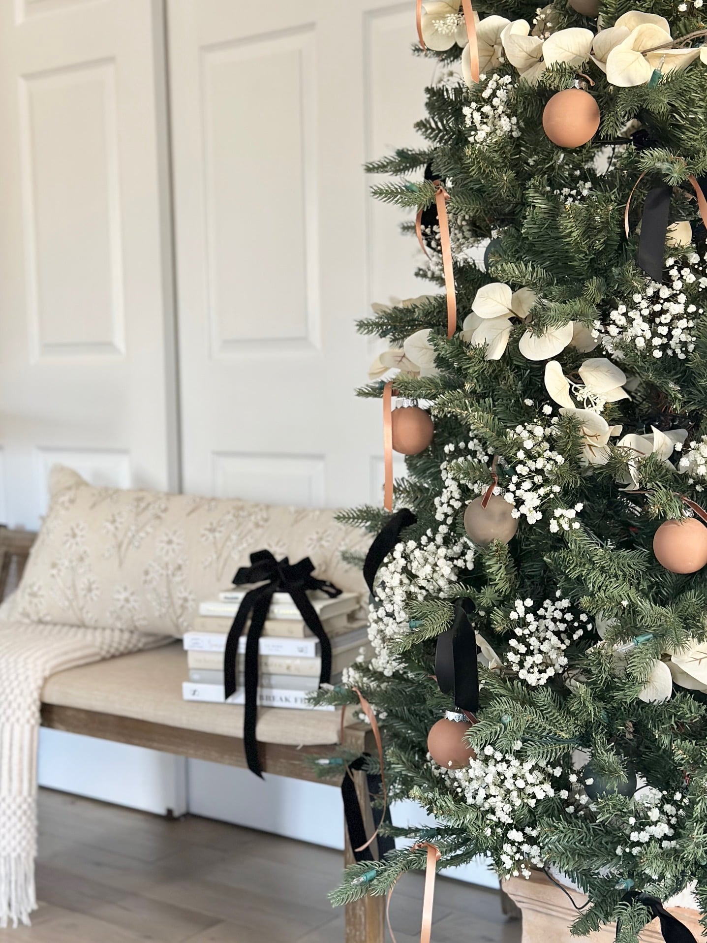 Fresh baby's breath on a Christmas tree in front of a bench. 