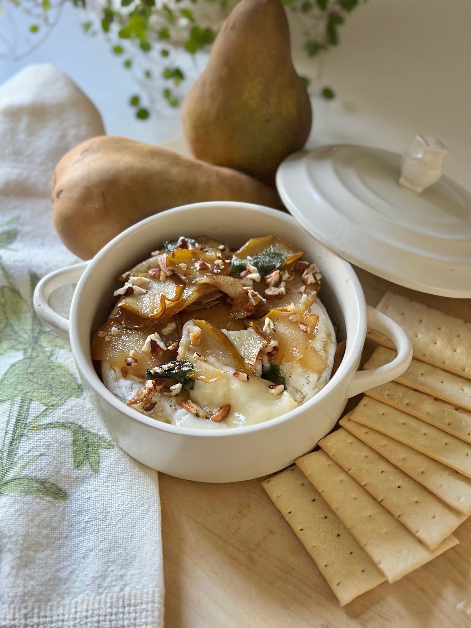 Baked brie with pears served with crackers.