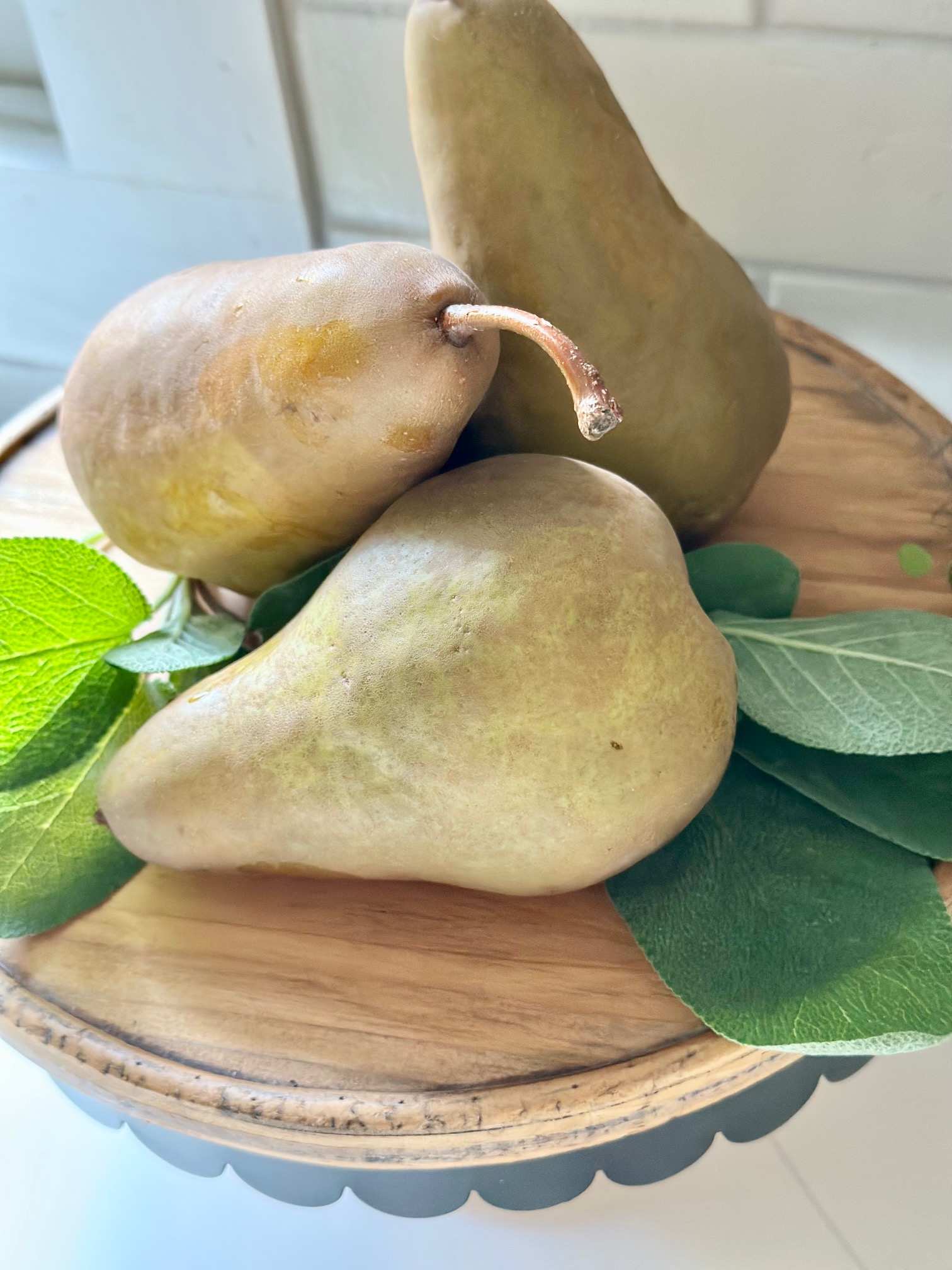 3 Bosc pears on a pedestal.