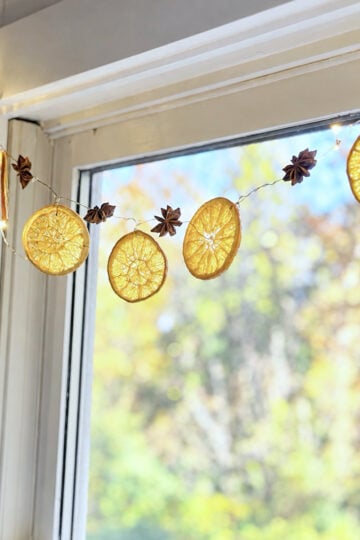 Dried orange garland hanging in a kitchen window.