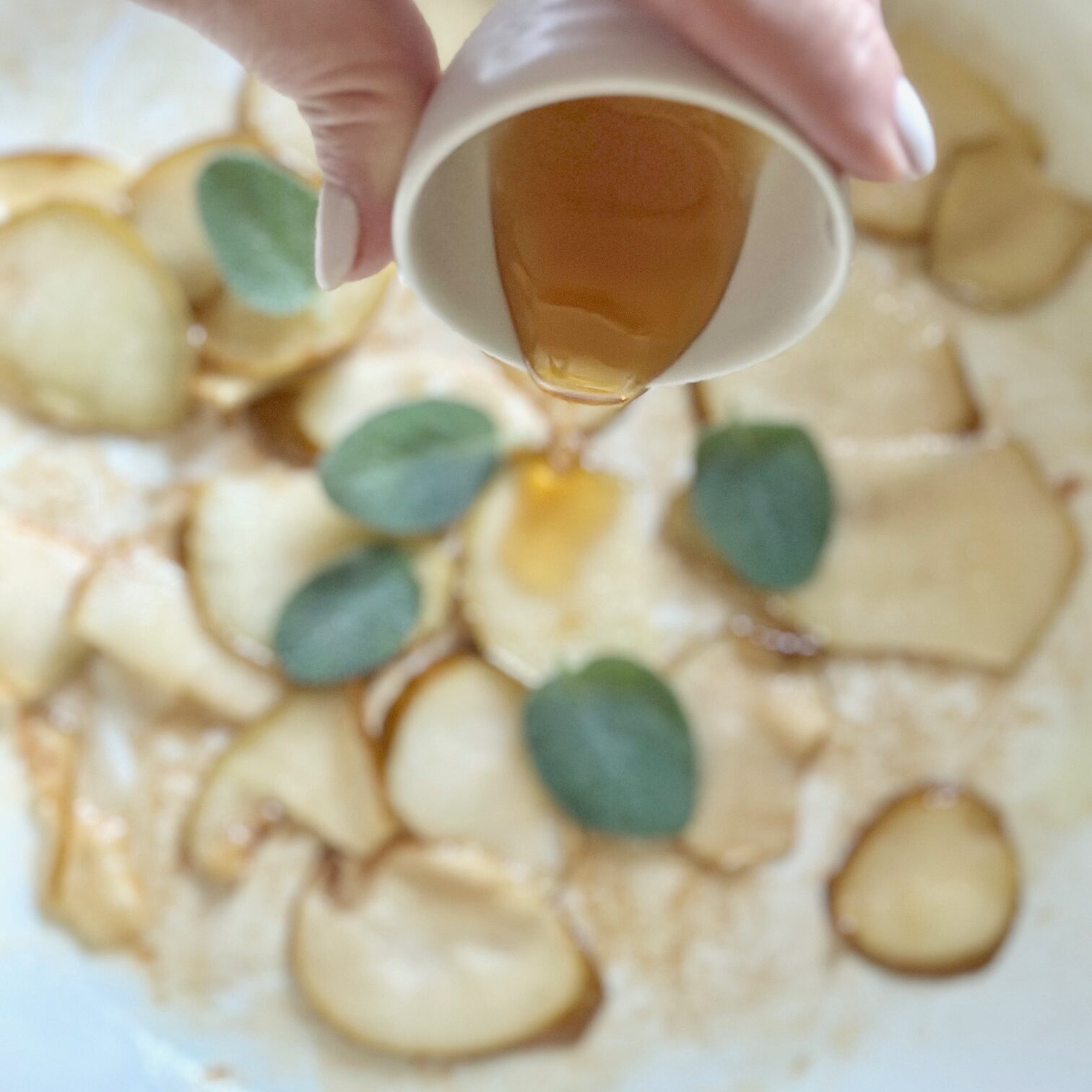 Pouring honey over pears and sage.